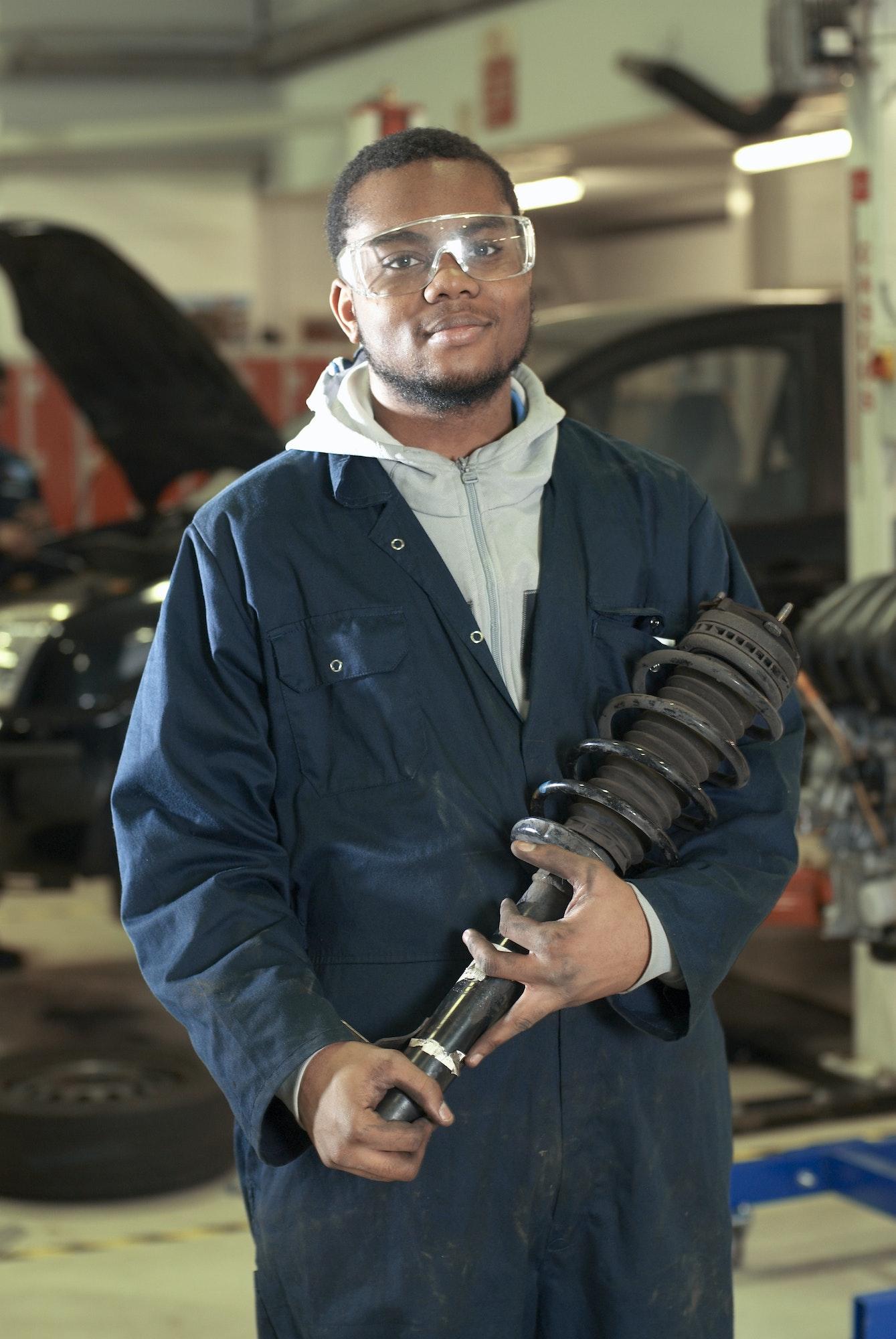 student-carrying-car-part-in-garage.jpg